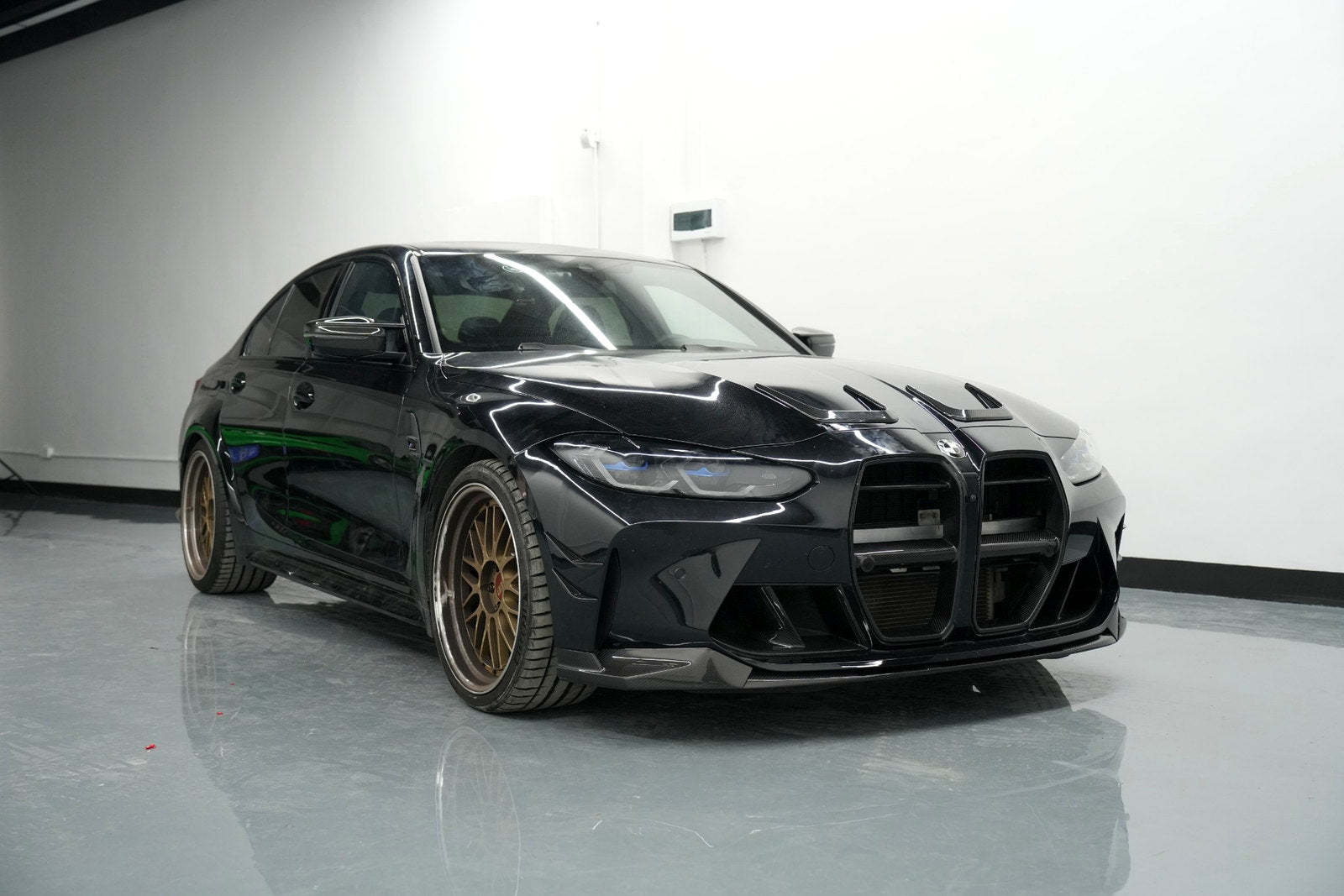 Completed BMW G80 M3 carbon fiber front-end upgrade from a low angle