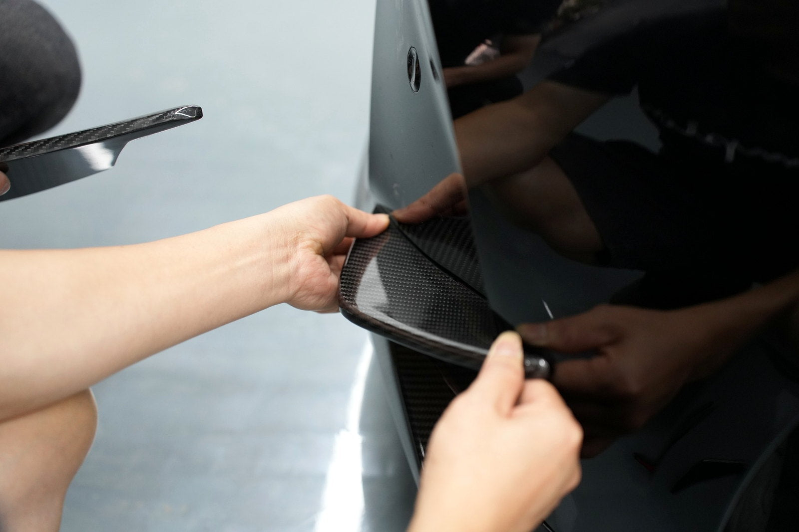 Carbon fiber bumper canard being test-fitted on a BMW G80 M3